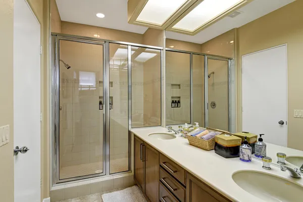 a bathroom with a double vanity sink mirror and shower