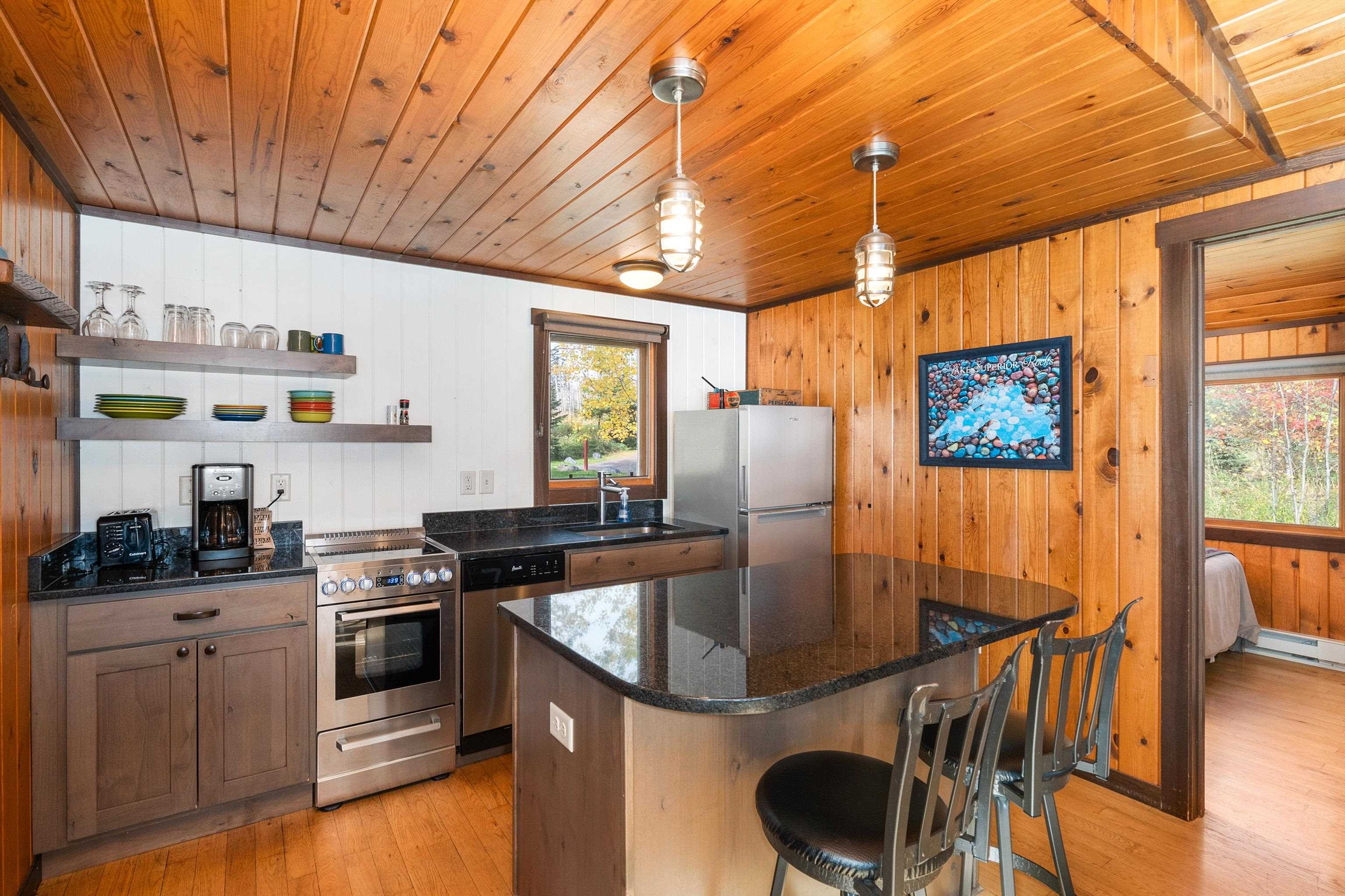 540 Old North Shore Road, Unit 7 Two Harbors, MN 55616 - Photo 14 of 61 Kitchen with open shelves, dark stone counters, pendant lighting, light wood-style flooring, and stainless steel appliances