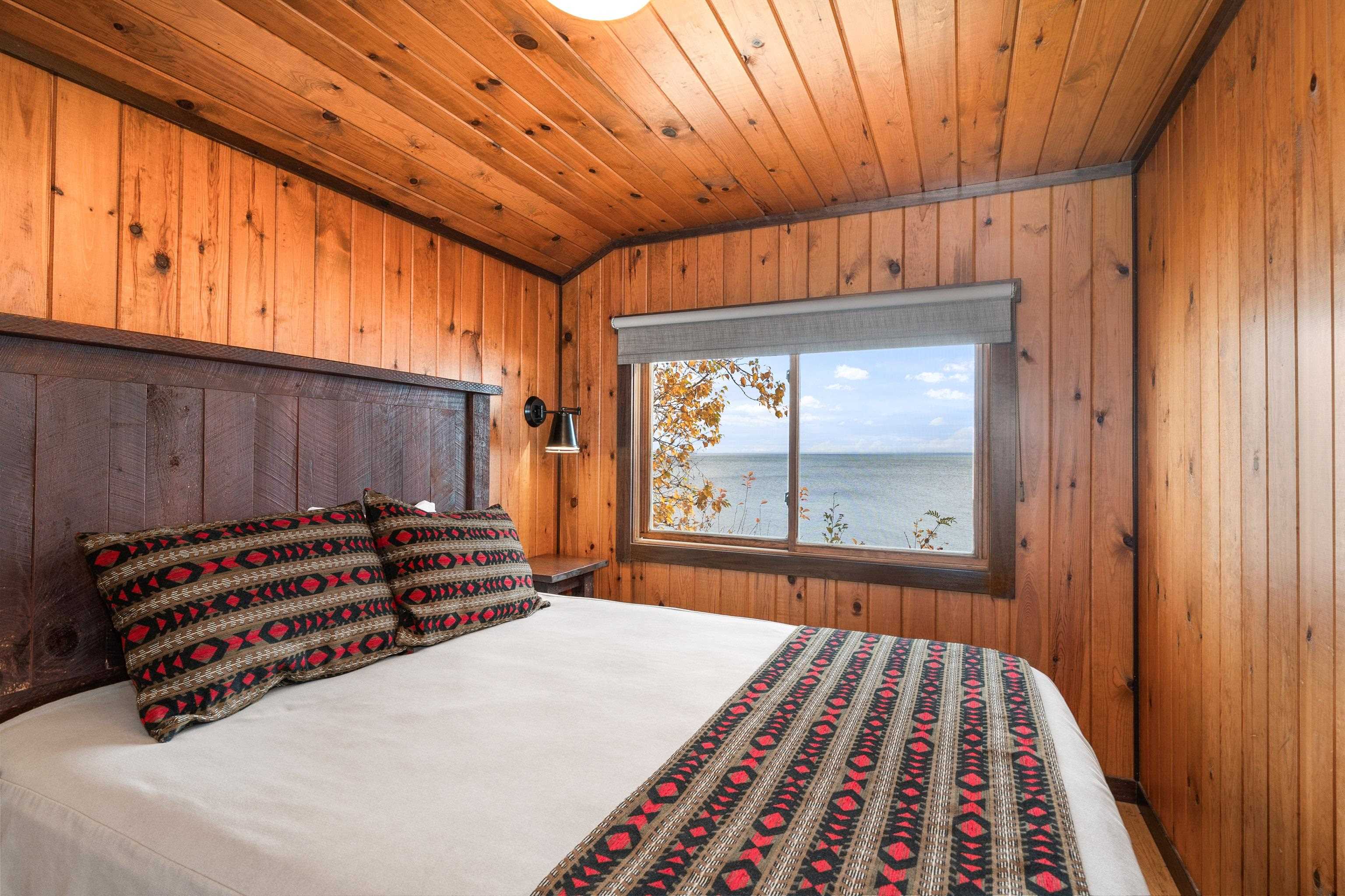 540 Old North Shore Road, Unit 7 Two Harbors, MN 55616 - Photo 20 of 61 Bedroom featuring a water view, wood walls, and wood ceiling