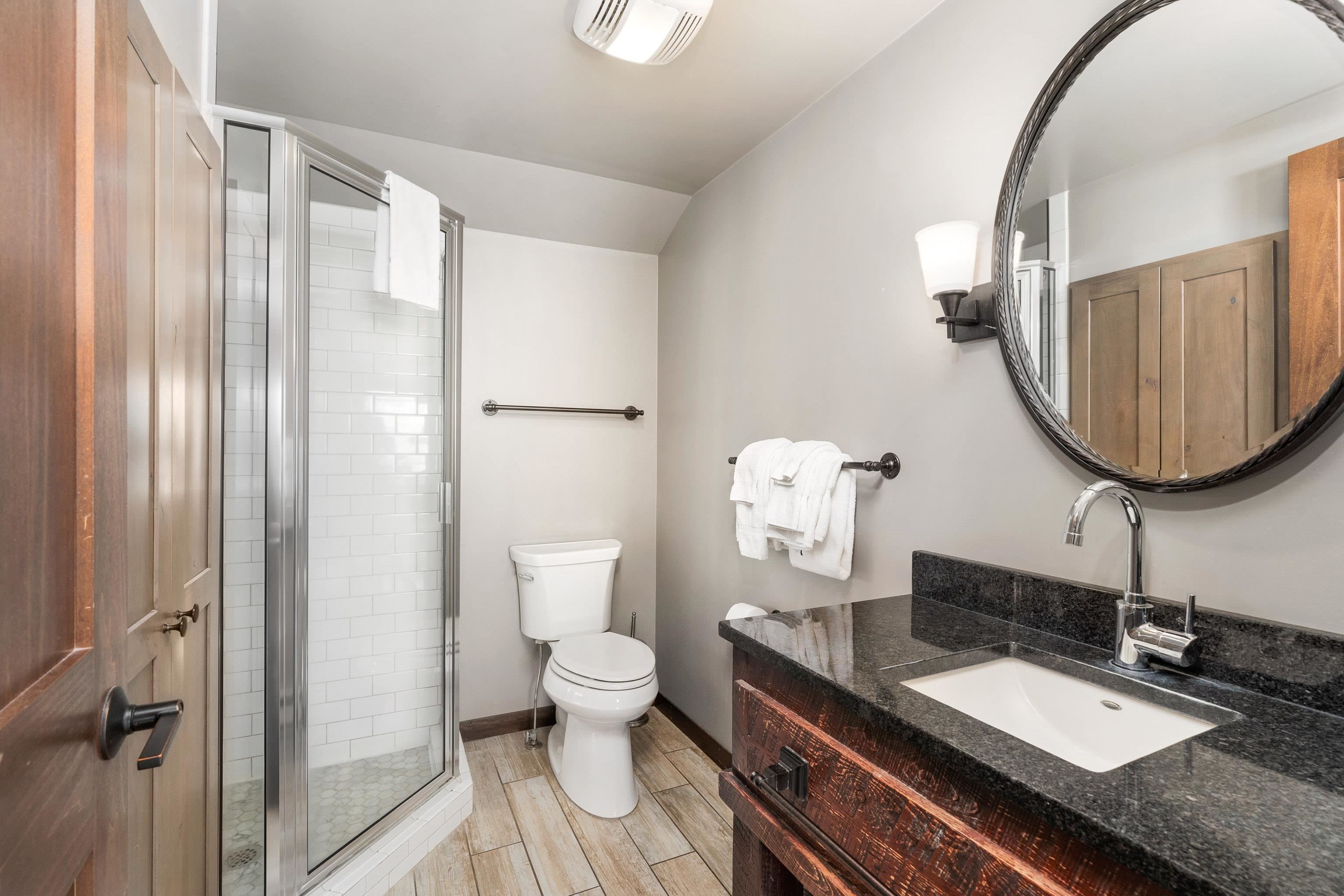 540 Old North Shore Road, Unit 7 Two Harbors, MN 55616 - Photo 24 of 61 Full bathroom featuring vanity, a stall shower, wood tiled floors, and lofted ceiling