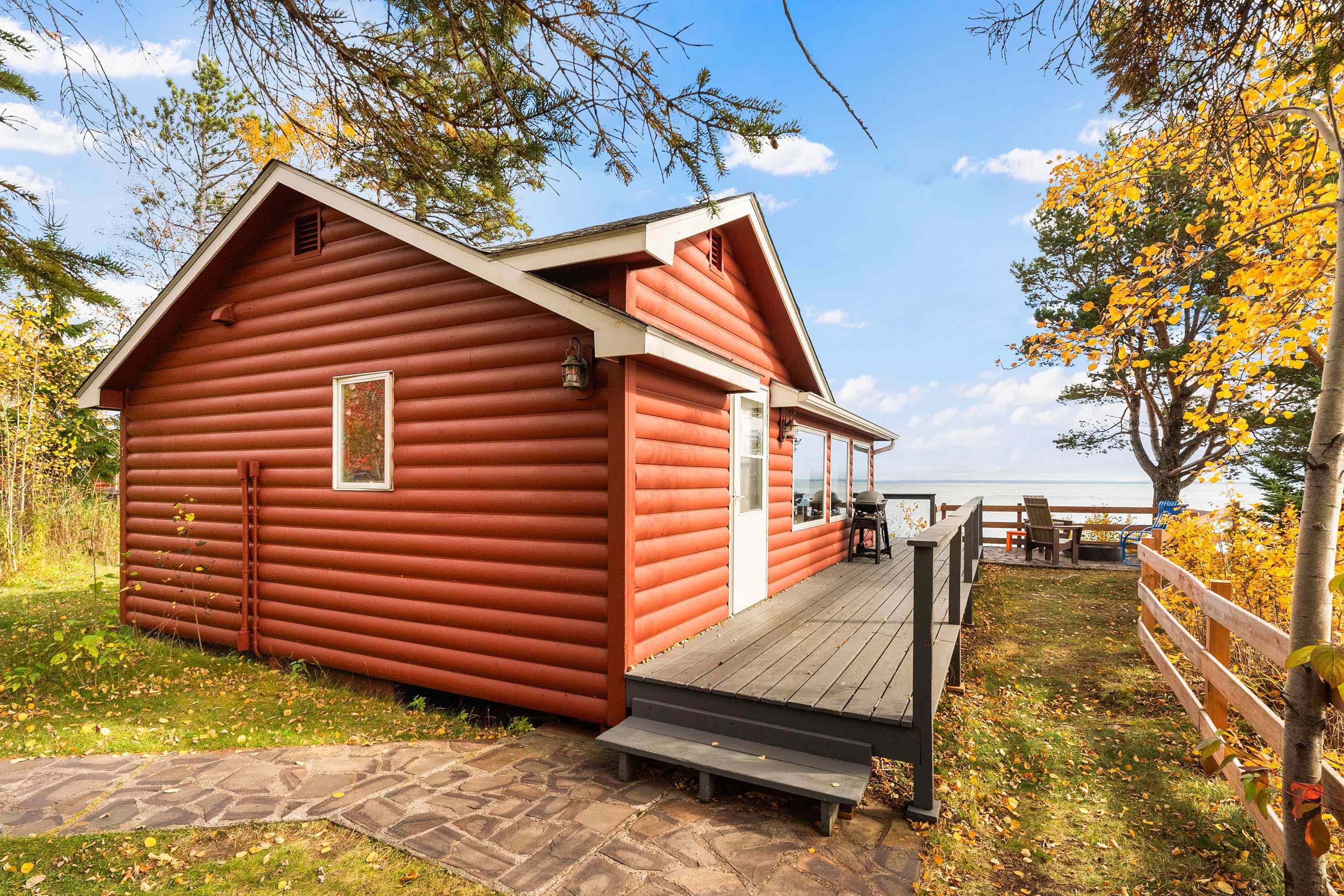 View of side of home with log veneer siding and a deck with water view