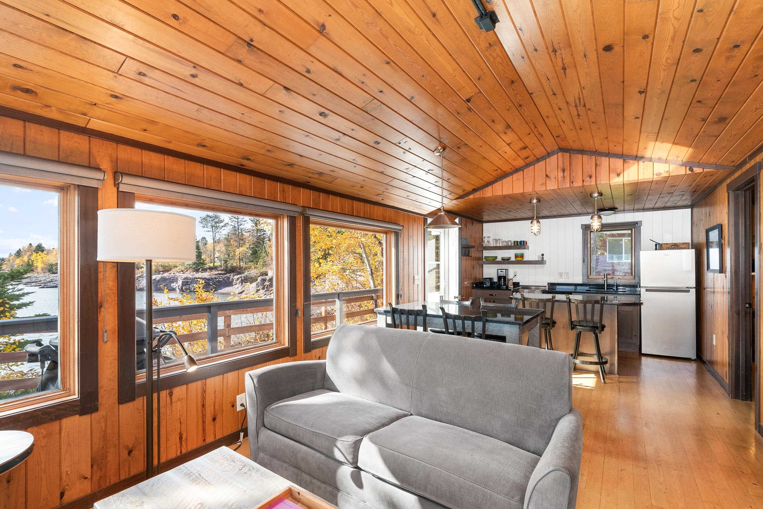 540 Old North Shore Road, Unit 7 Two Harbors, MN 55616 - Photo 8 of 61 Living area with wood walls, light wood-type flooring, vaulted ceiling, and wood ceiling