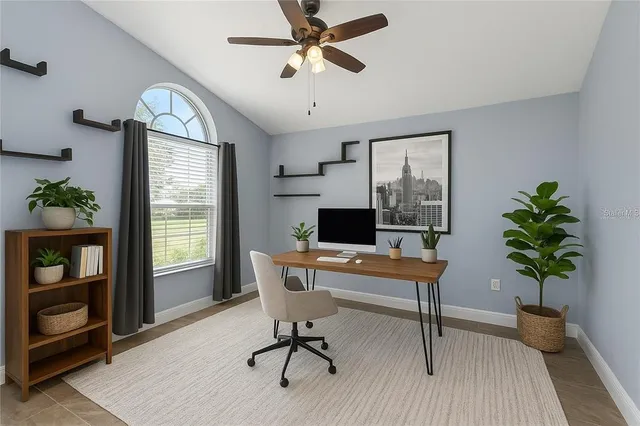 a view of a workspace with furniture and a window