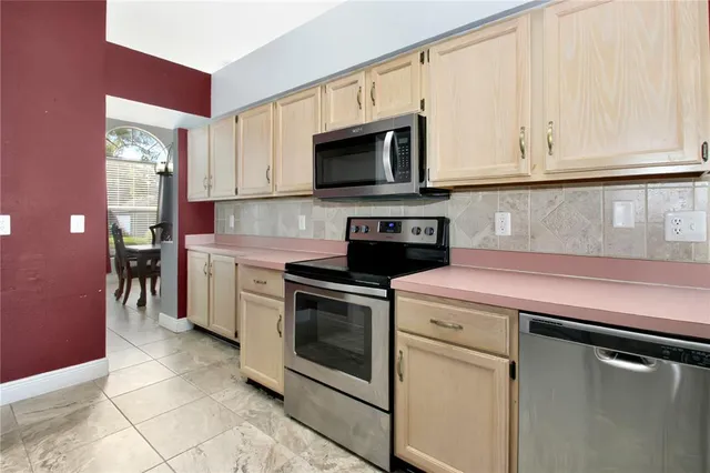 a kitchen with stainless steel appliances granite countertop a stove a microwave and a white cabinets