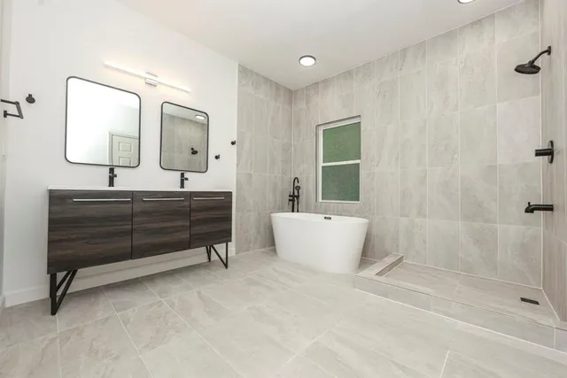 a spacious bathroom with a bathtub shower sink and mirror