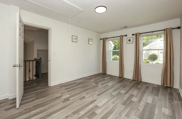 an empty room with wooden floor and a window