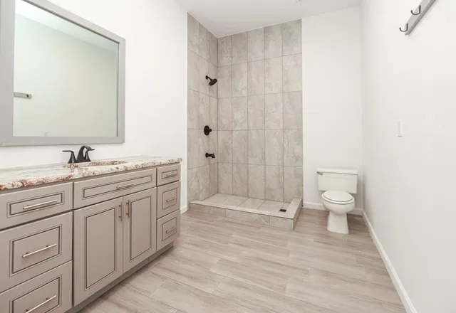 a bathroom with a double vanity sink toilet and shower