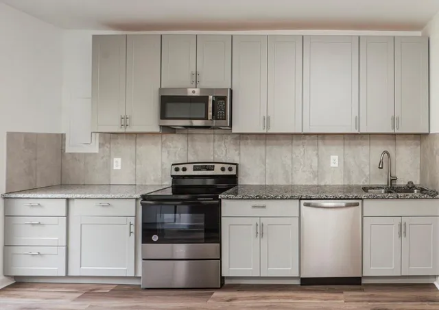 a kitchen with white cabinets and appliances