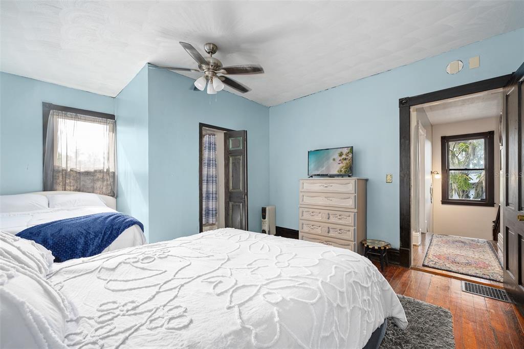 228 West Howry Avenue DeLand, FL 32720 - Photo 28 of 55 a bedroom with a large bed and a chandelier