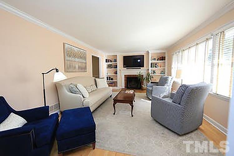 4229 Rowan Street Raleigh, NC 27609 - Photo 4 of 30 a living room with furniture a large window and a fireplace