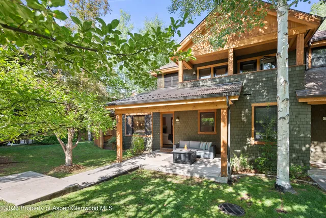 a view of a house with backyard garden and patio
