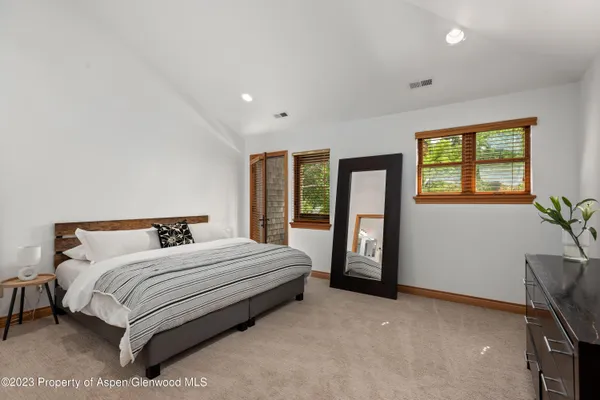 a bedroom with a bed lamp and a window
