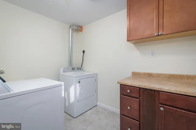 a utility room with cabinets washer and dryer