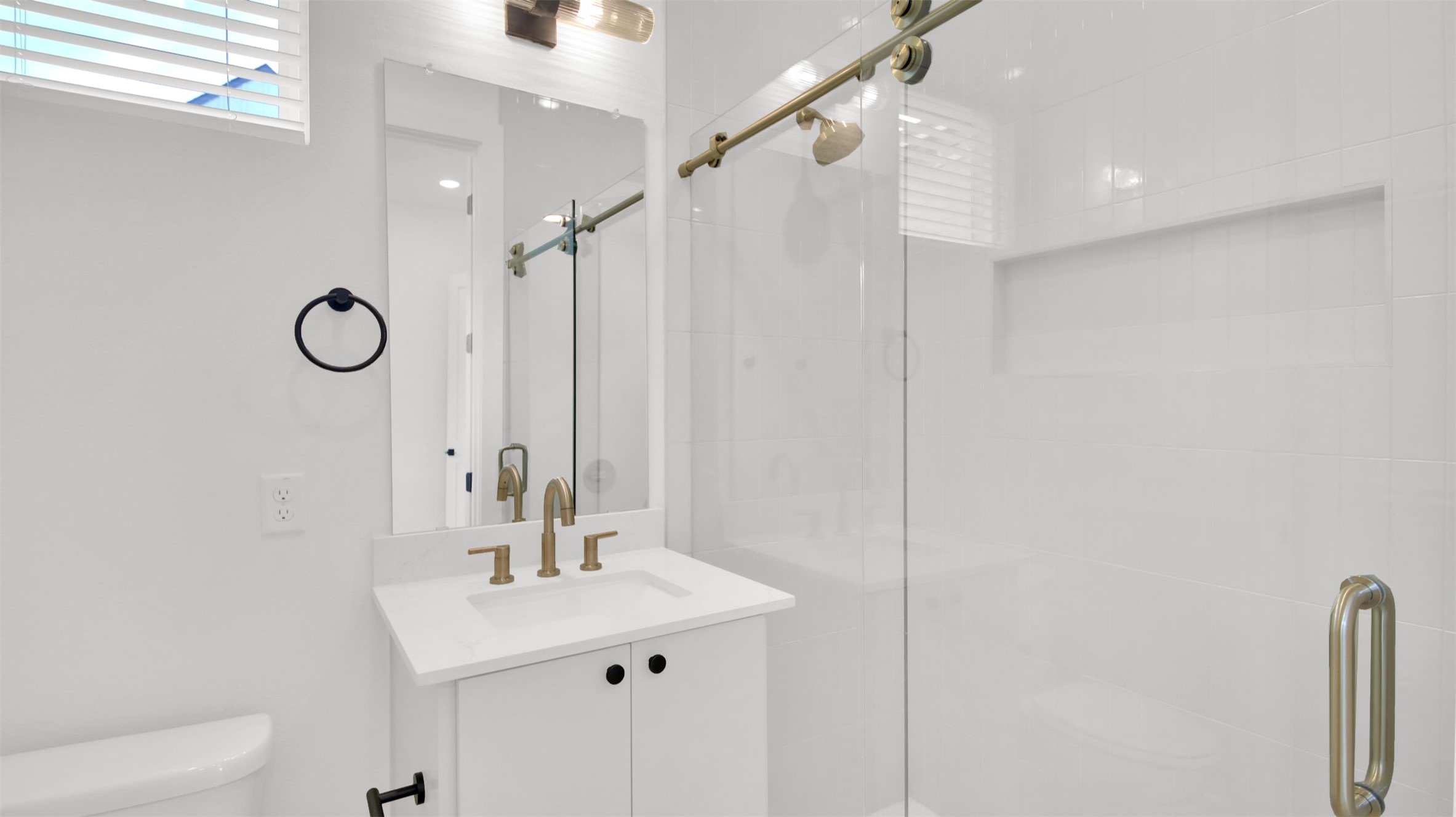 7208 Providence Avenue, Unit 1 Austin, TX 78752 - Photo 13 of 26 Modern bathroom featuring a white vanity with a quartz countertop, a vanity mirror with a light fixture, and a glass-enclosed shower