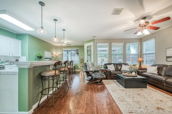 a very nice looking living room with a large window and wooden floors