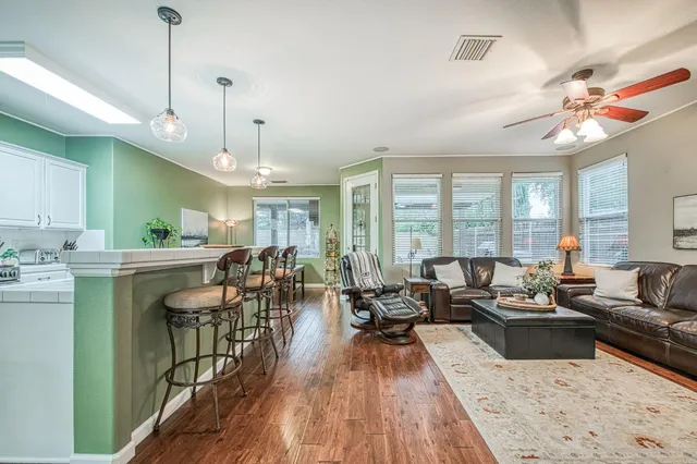 a very nice looking living room with a large window and wooden floors