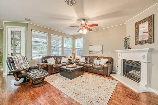 a living room with furniture fireplace and a large window