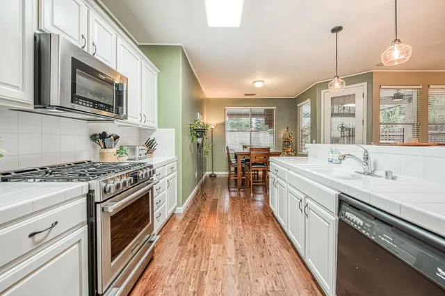 a kitchen with stainless steel appliances a stove sink microwave and cabinets