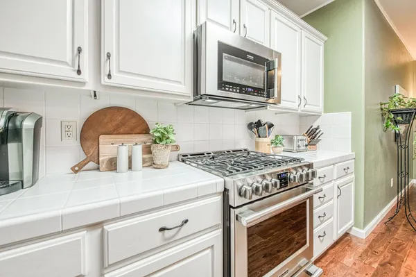 a kitchen with stainless steel appliances granite countertop a stove a microwave and cabinets
