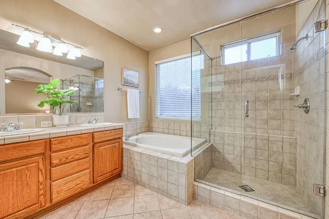a bathroom with a bathtub shower sink and mirror