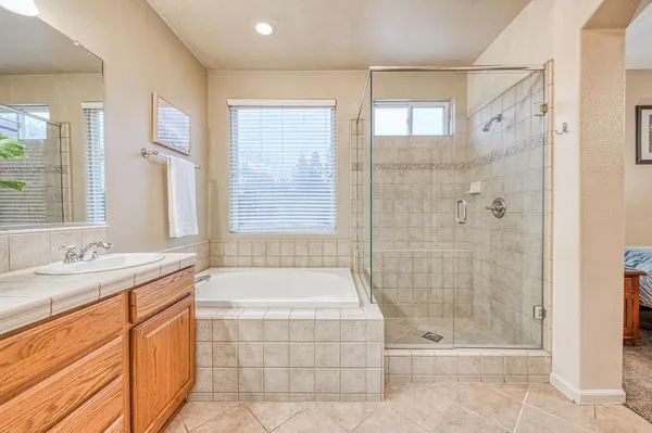 a bathroom with a tub sink and mirror