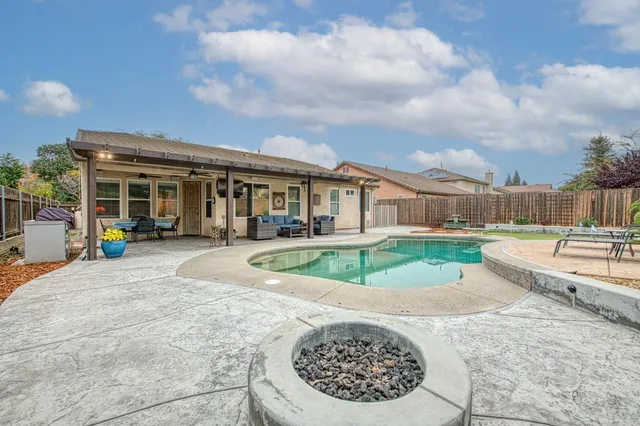 a view of a house with a backyard and a fountain