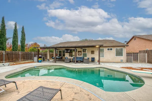 a view of a house with swimming pool and sitting area
