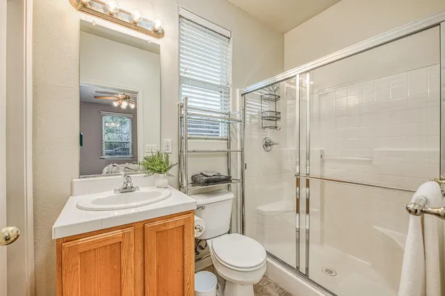 a bathroom with a granite countertop sink toilet and shower