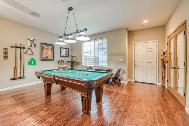 a room with pool table and windows