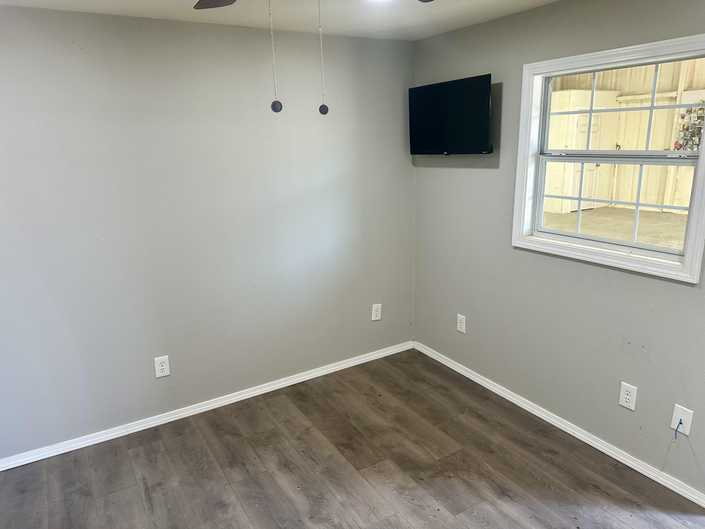 9223 County Road 6700 Lubbock, TX 79403 - Photo 31 of 60 an empty room with wooden floor and windows