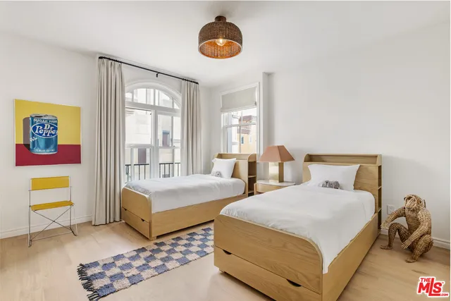 a bedroom with two beds and a window