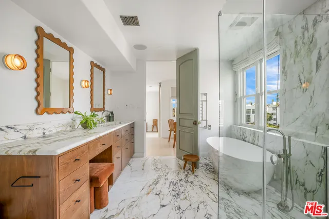 a spacious bathroom with a tub sink and mirror