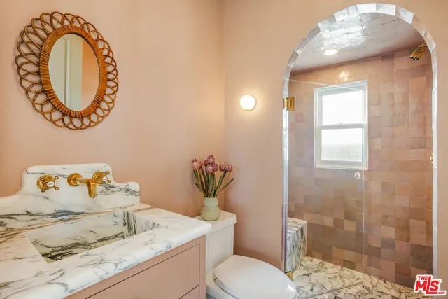 a bathroom with a toilet sink vanity and mirror