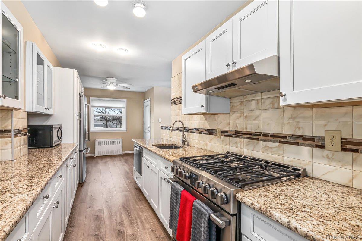 10 Lenox Road, Unit 2F Rockville Centre, NY 11570 - Photo 9 of 21 a kitchen with stainless steel appliances granite countertop a stove and a sink