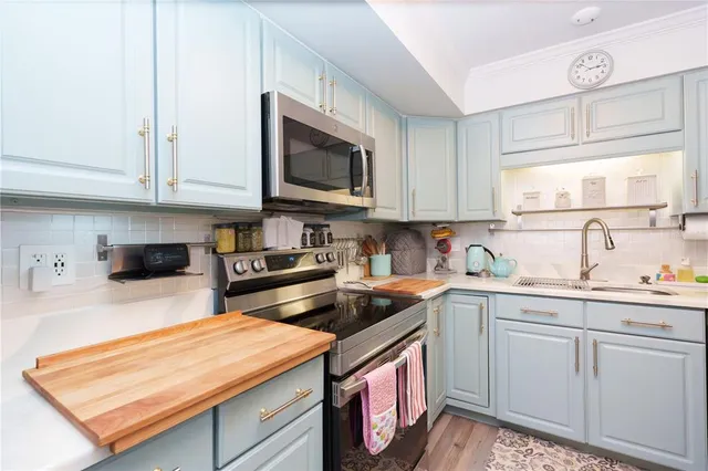 a kitchen with stainless steel appliances granite countertop a sink stove and microwave