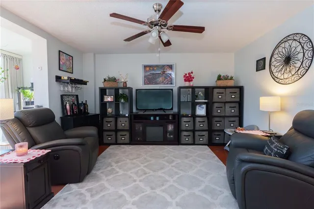 a large bedroom with a bed a mirror and a flat tv screen on dresser