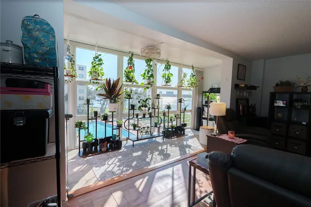 a living room with furniture a flat screen tv and a floor to ceiling window