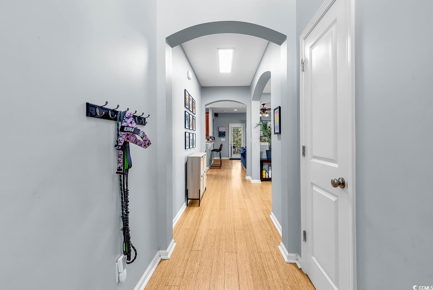 1005 Elysium Court Murrells Inlet, SC 29576 - Photo 3 of 37 Hallway with arched walkways and light wood finished floors