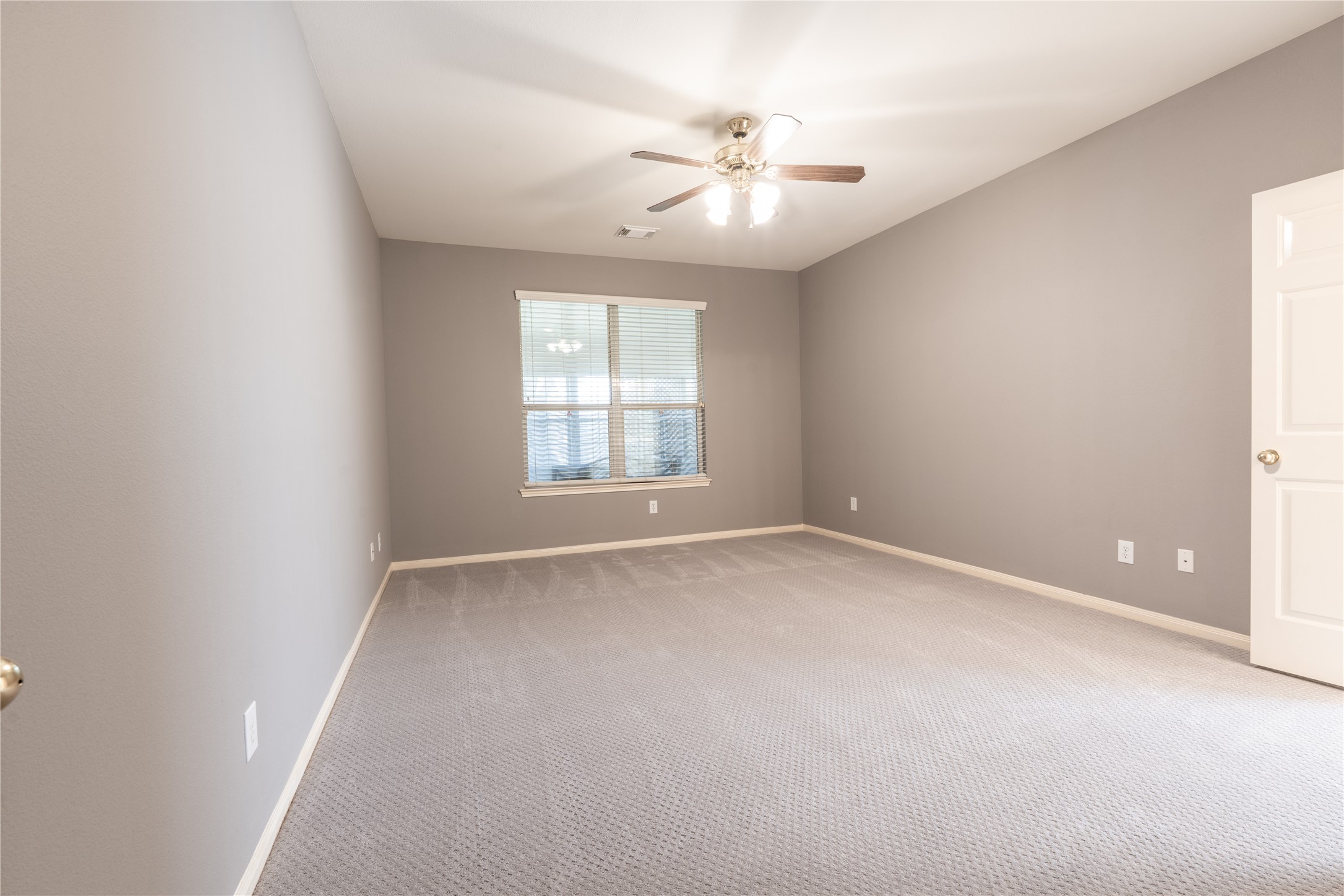 10619 Crownsedge Drive Spring, TX 77379 - Photo 14 of 38 This room features neutral gray walls, soft carpeting, a ceiling fan with lights, and a window providing natural light. It's spacious and ready for personalization.