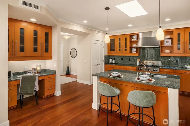 a kitchen with stainless steel appliances granite countertop a stove a sink and a refrigerator