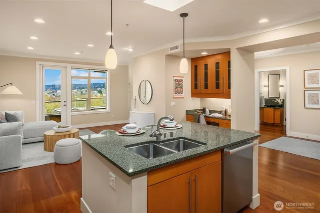 a kitchen with granite countertop a sink a counter top space and living room view