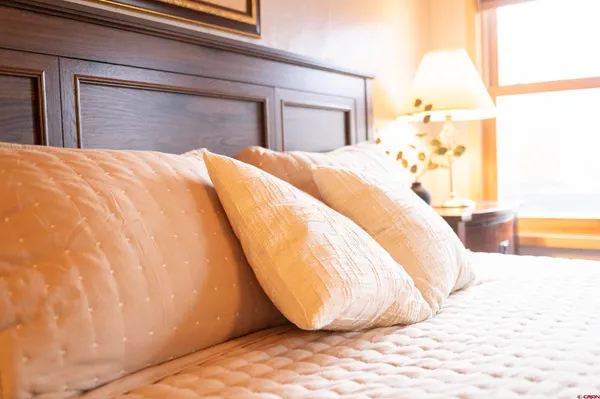 a bedroom with a bed and mirror on the wall