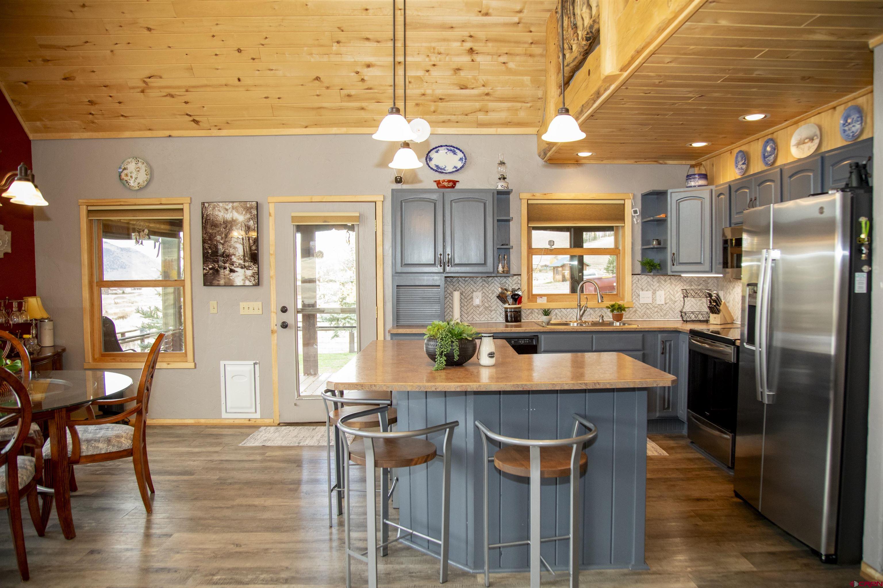 258 Diamond Road Creede, CO 81130 - Photo 6 of 30 an open kitchen with granite countertop a table chairs stove and refrigerator