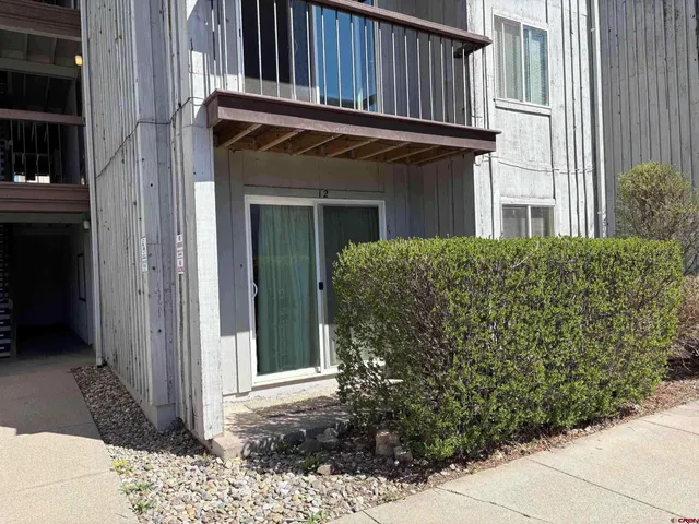 a view of a house with plants and wooden fence