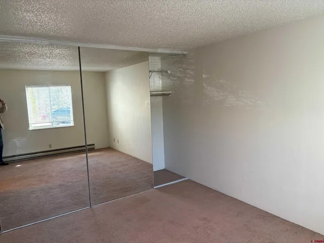 an empty room with windows and closet