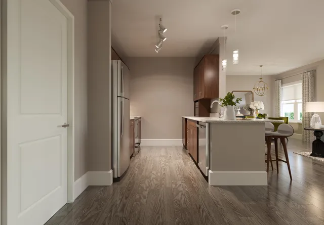 a kitchen with stainless steel appliances granite countertop a refrigerator a sink dishwasher a stove and a dining table with wooden floor