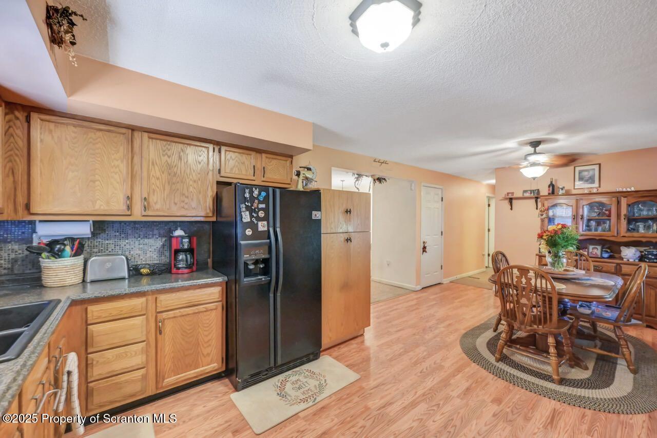 145 Tunnel Road Nicholson, PA 18446 - Photo 20 of 70 a kitchen with stainless steel appliances wooden cabinets refrigerator dining table and chairs