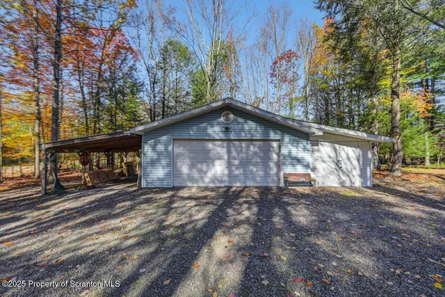 a view of a livingroom with a ceiling fan & windows