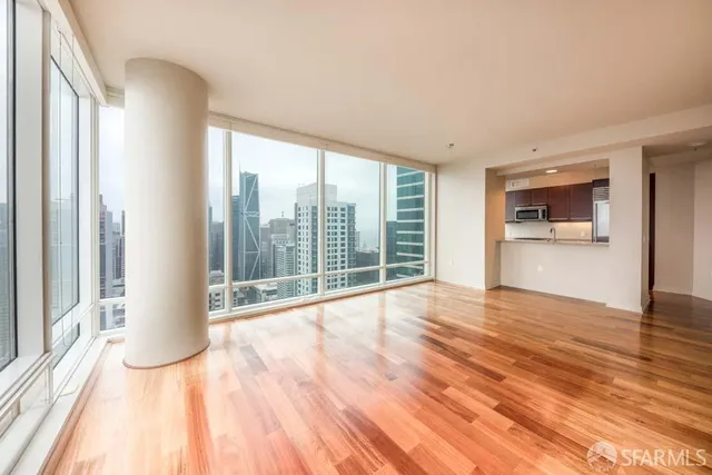 a view of a room with wooden floor and windows