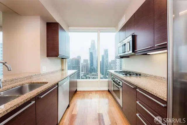 a kitchen with a sink stove top oven and refrigerator